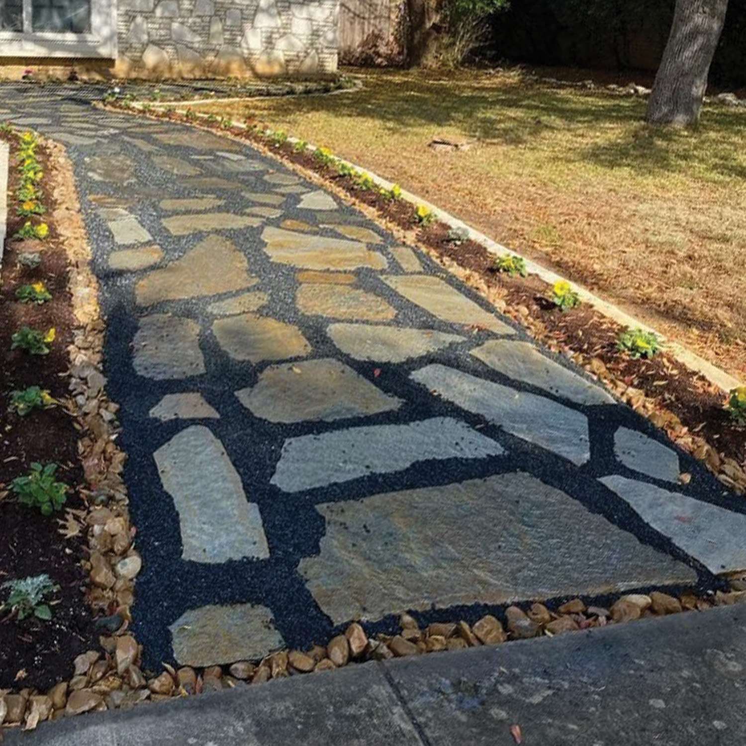 Landscaping Services San Antonio - slate stone walkway surrounded by crushed black gravel